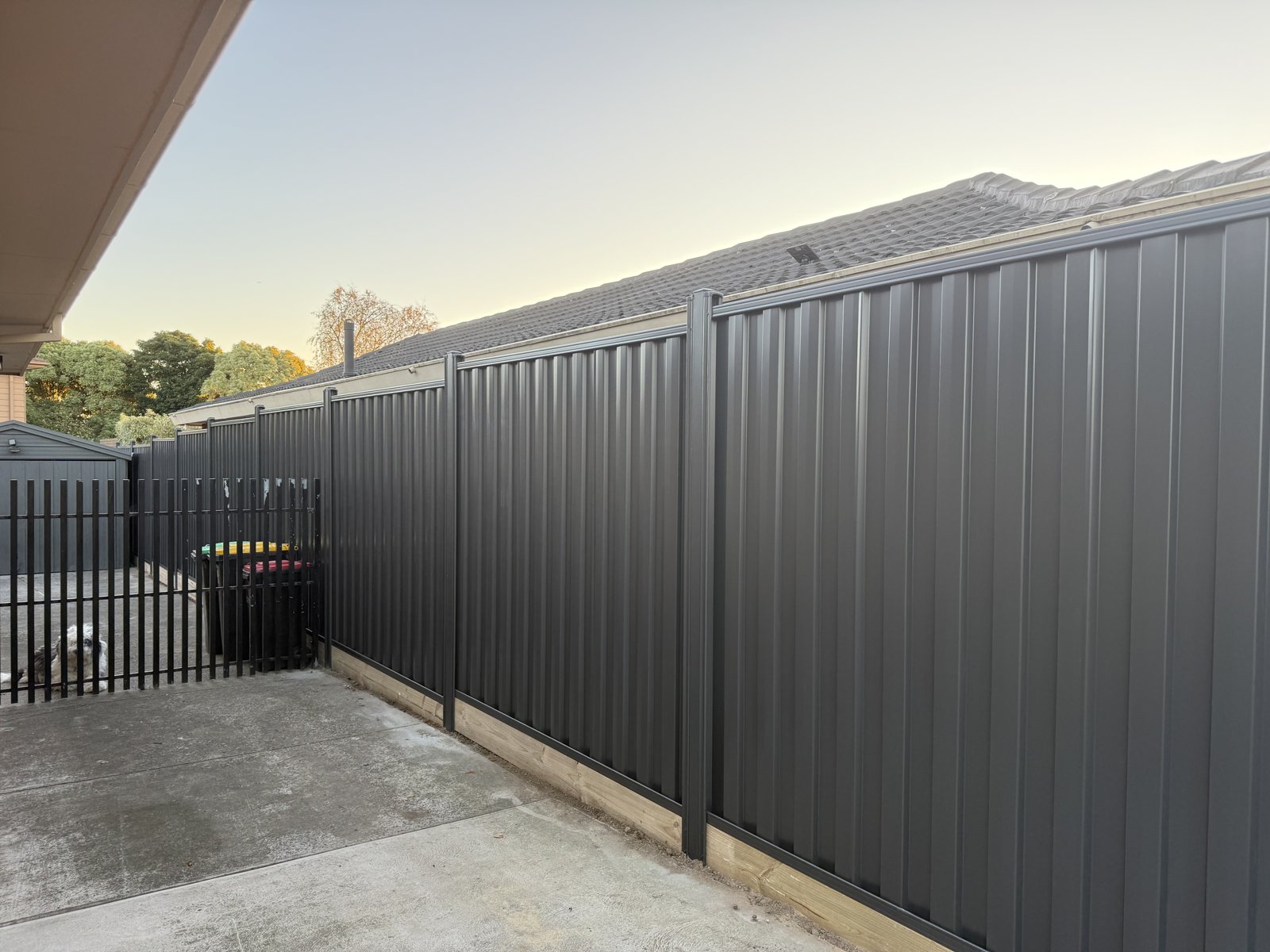Dark Colorbond fence along a driveway