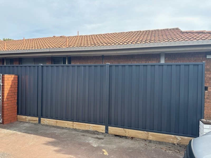 Blue steel Colorbond fence with a sliding gate section